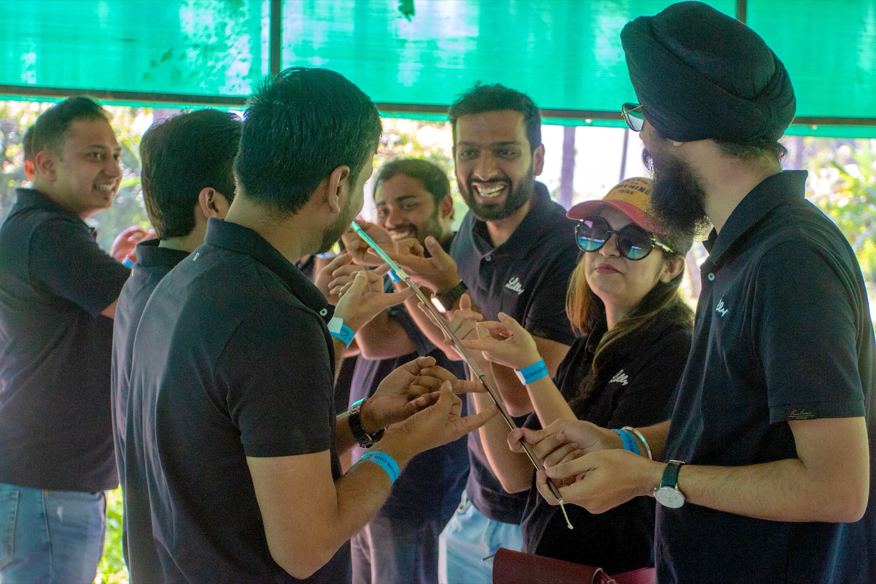 A team laughing through the helium stick challenge