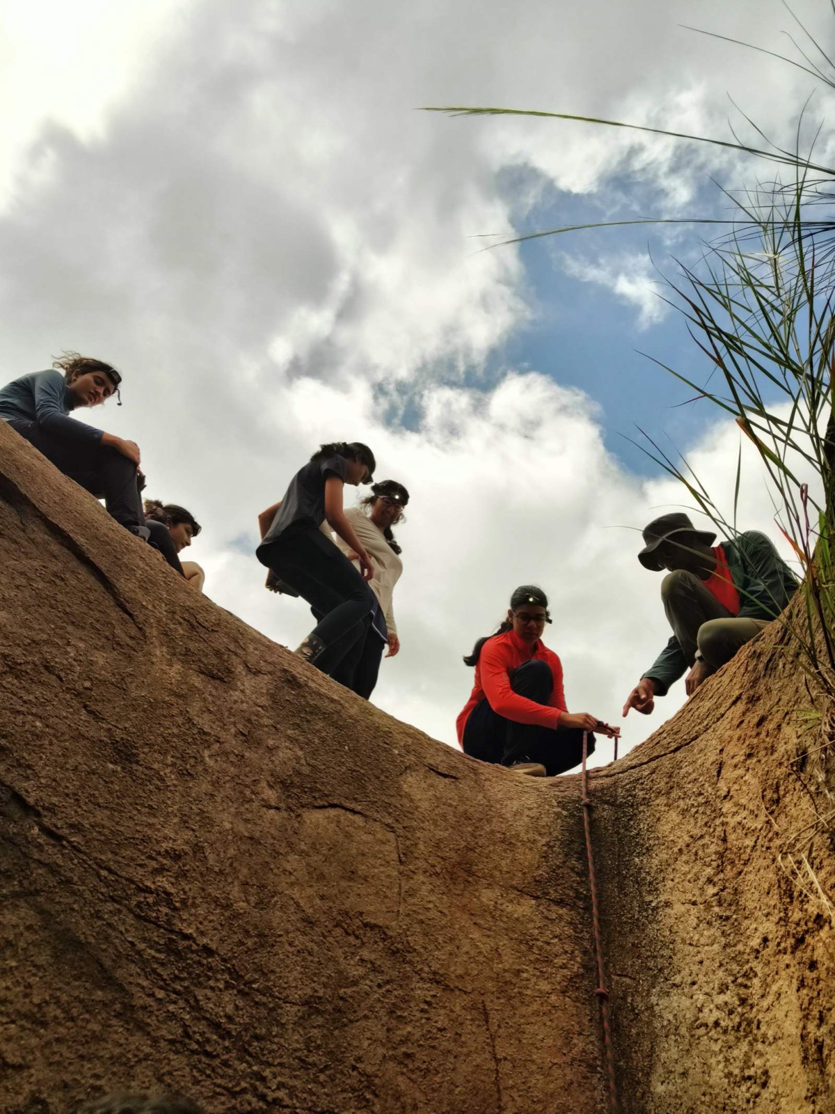 Trekkers climbing upward through a narrow rock chimney
