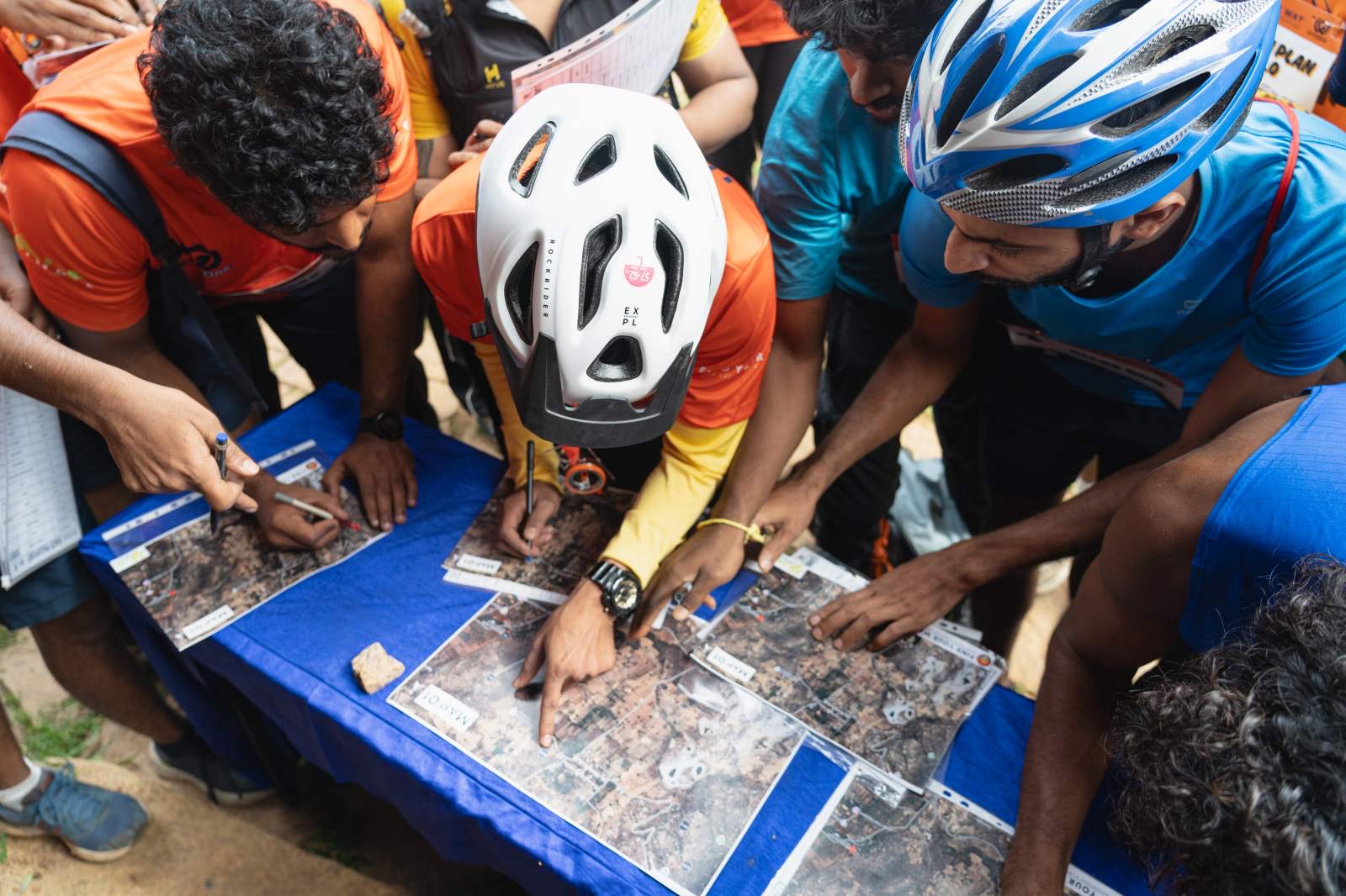 Helmeted racers bent over their maps, planning a route